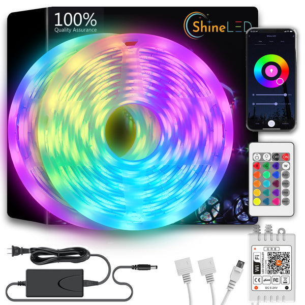 The Shine LED 32.8ft Smart WiFi RGB Strip Light boasts 300 color-changing LEDs that provide vibrant, multicolored illumination. The packaged set includes a remote control, smartphone app display, voice control feature, power adapter, various connectors, and the LED light strip coiled in a circular shape. The packaging proudly states "100% Quality Assurance.”